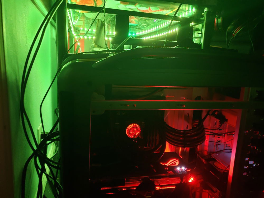 Showing the glow from the Glasstop Desk behind the PC. It has an LED strip for lighting behind the monitors while playing in a dark environment