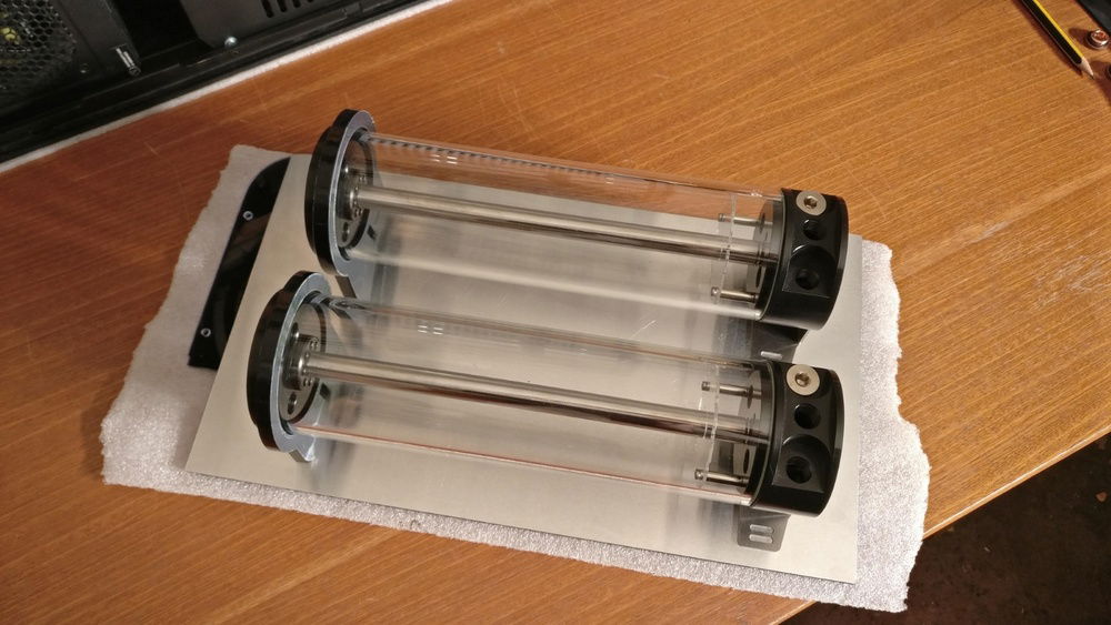 That's how the reservoirs should be mounted. They get a bit heavy when filled with fluid, only the acrylic plate wouldn't have been stable enough to hold them.